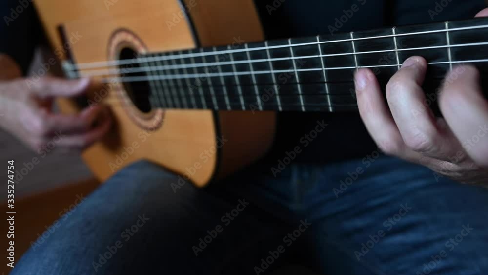 Man playing the Spanish guitar at home Man playing the Spanish guitar at home