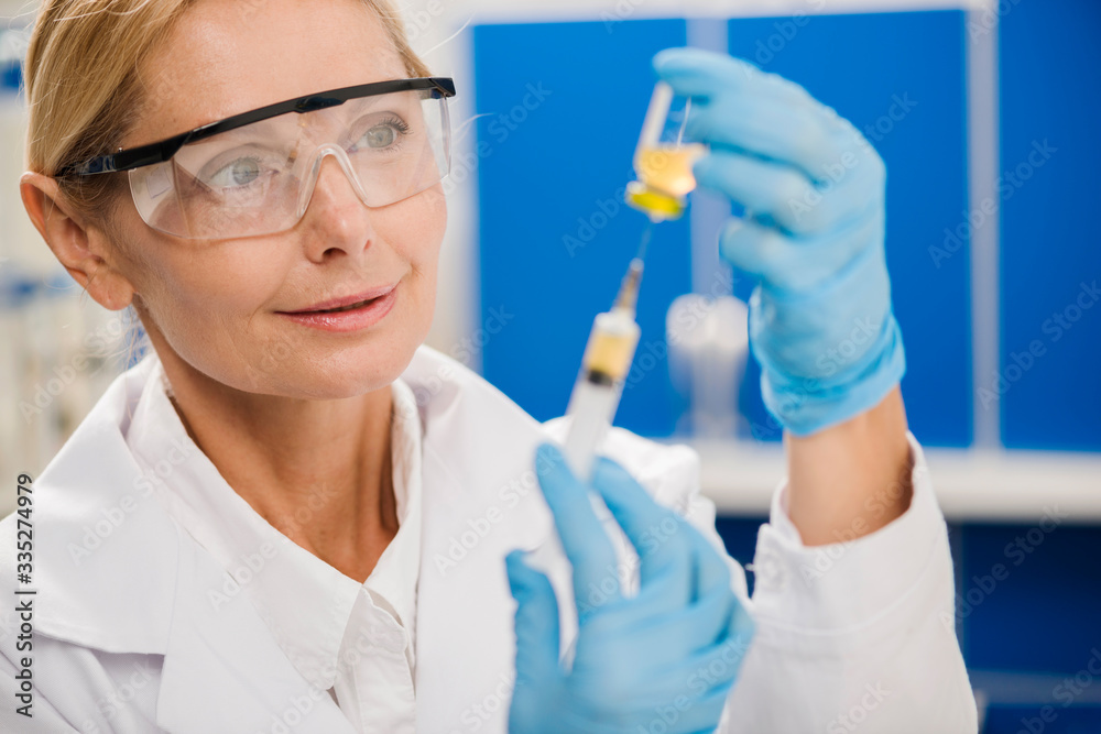 Female scientist using a syringe Female scientist using a syringe
