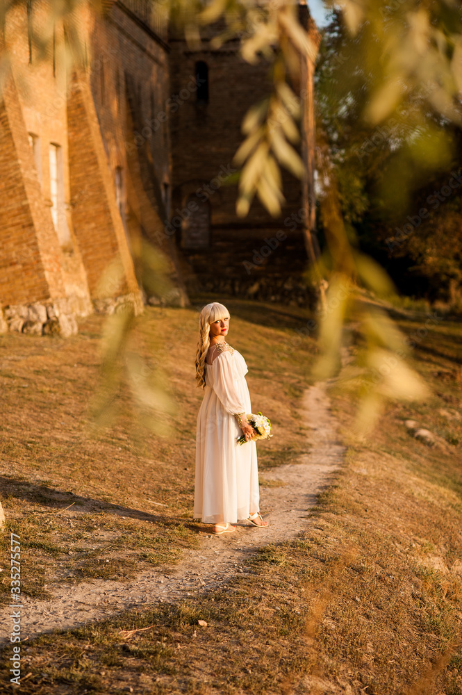 blonde girl in a white dress on nature near architectural monuments in the open air blonde girl in a white dress on nature near architectural monuments in the open air