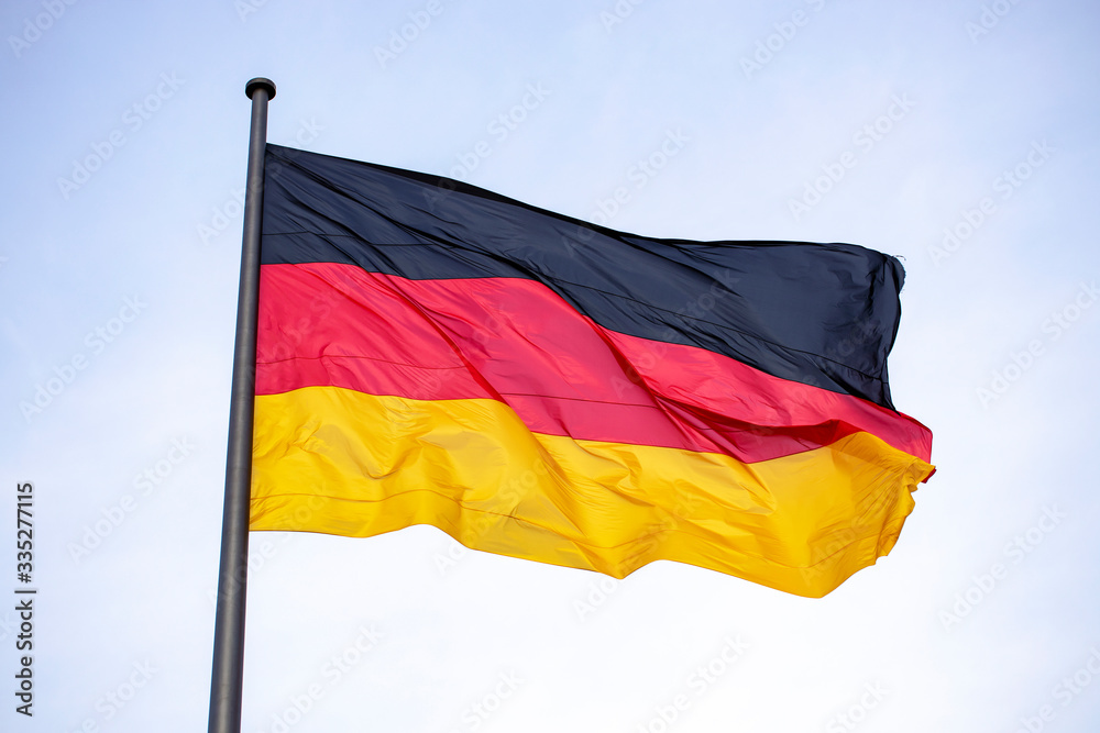 Germany flag waving in the wind close-up against a blue sky Germany flag waving in the wind close-up against a blue sky