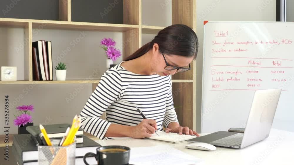 4k video of student study online learning writing notes on a desk, distant education e learning course in library. 4k video of student study online learning writing notes on a desk, distant education e learning course in library.