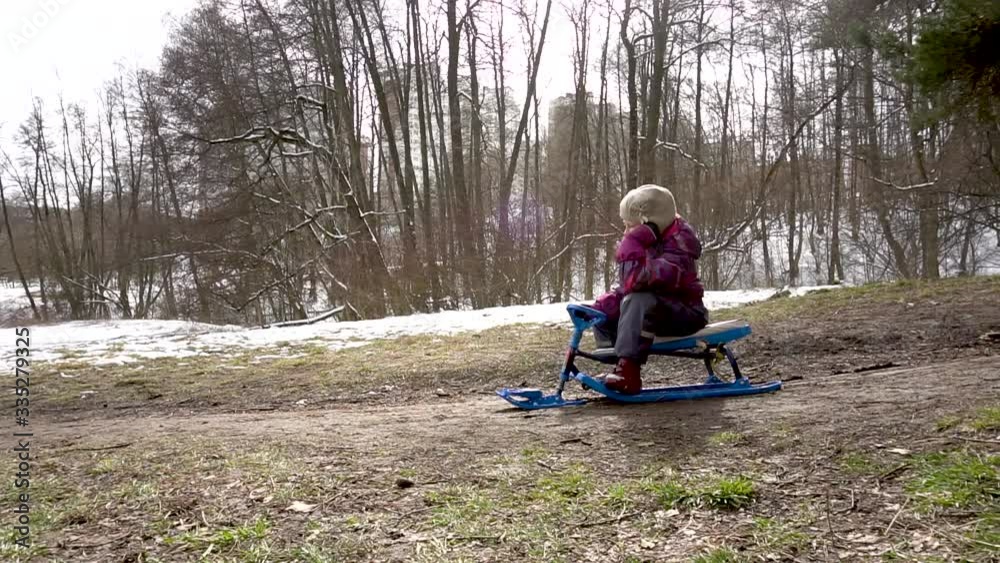 Girl Uran sitting on the ground around early spring, snow Girl Uran sitting on the ground around early spring, snow