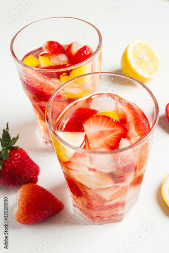 Strawberry detox water with lemon on white background.
