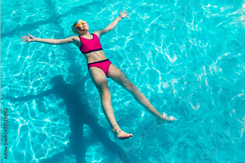 girl swims in a blue pool