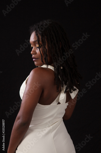 Pretty black woman in a white dress, looking thoughtful