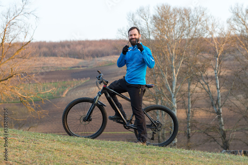 Cyclist in pants and fleece jacket on a modern carbon hardtail bike with an air suspension fork. The guy on the top of the hill rides a bike.