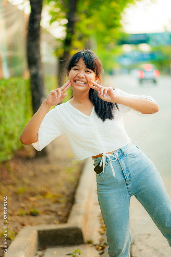 lovely face of asian teenager wearing easy casual clothes standing beside city street lovely face of asian teenager wearing easy casual clothes standing beside city street