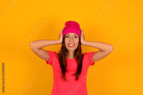 cute young woman in pink hat t-shirt on yellow background logo emotion smile © Диана Красникова