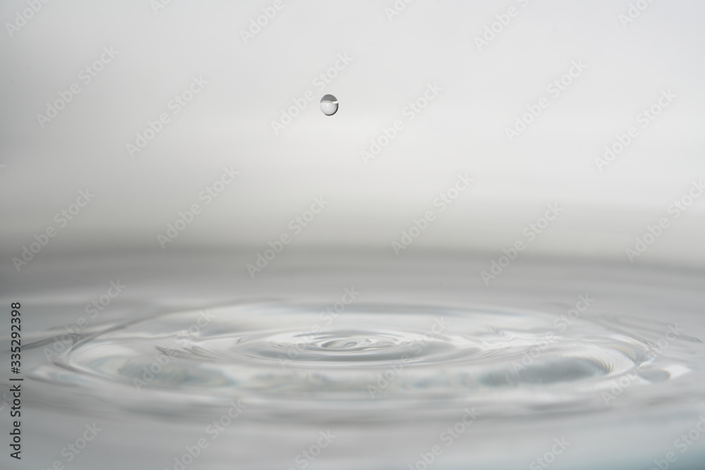 Water splash from falling drop of water grey background Water splash from falling drop of water grey background