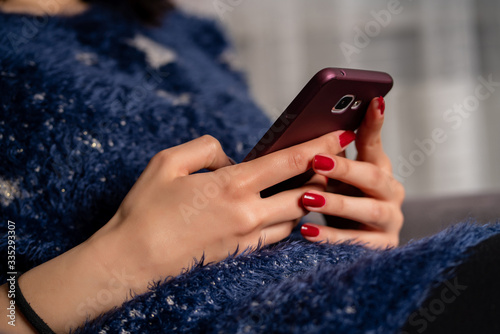 Young woman is using phone from home during quarantine time at coronavirus.