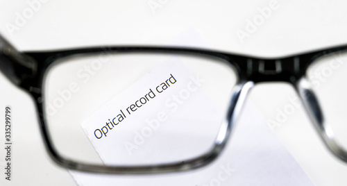 Optical record card seen through a pair of glasses with lenses to correct short sightedness isolated against a plain white background photo