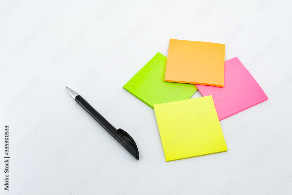 Pen and note pads in day glo colors isolated against a plain white background. Pen and note pads in day glo colors isolated against a plain white background.