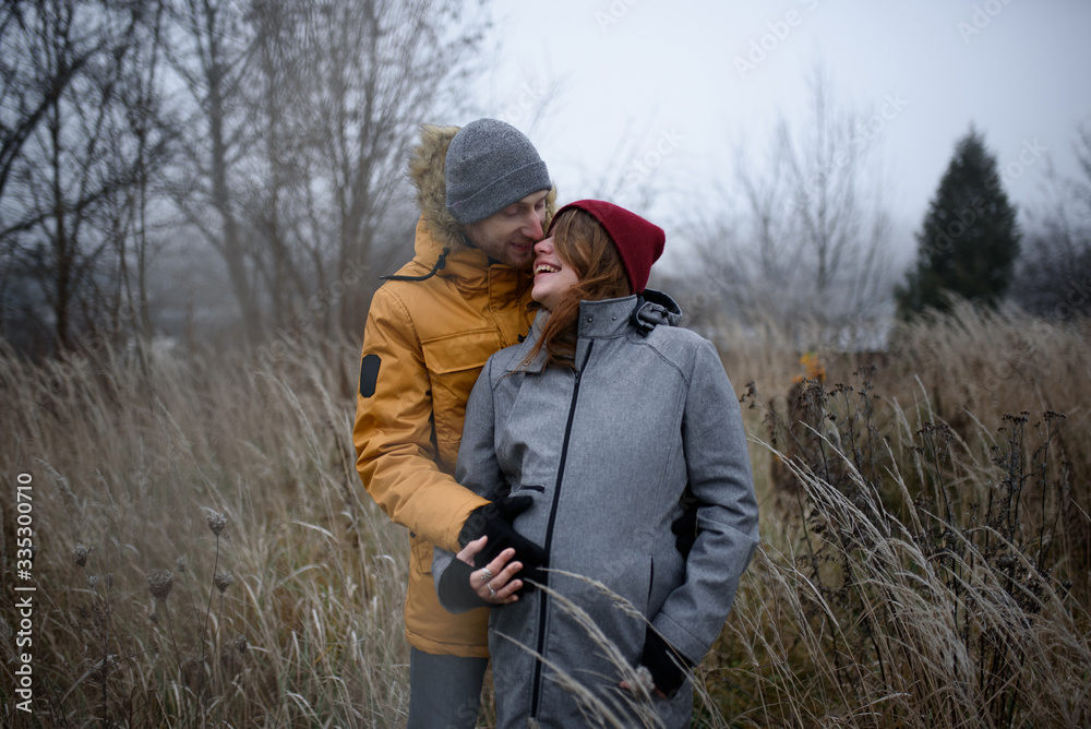 loving pregnant couple are walking outside the city in late autumn. loving pregnant couple are walking outside the city in late autumn.