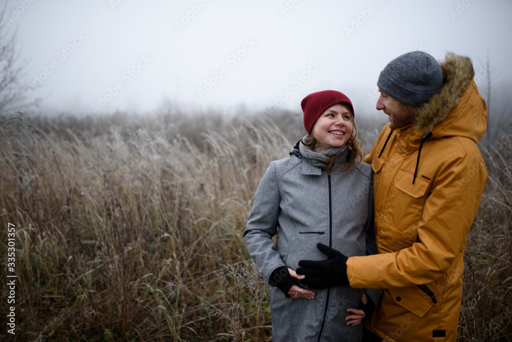 loving pregnant couple are walking outside the city in late autumn. loving pregnant couple are walking outside the city in late autumn.