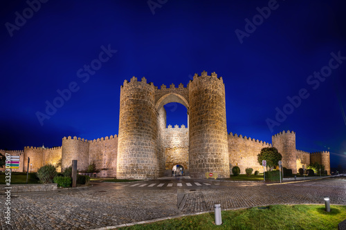 Avila, Spain. View of historic city gate Puerta de San Vicente at dusk