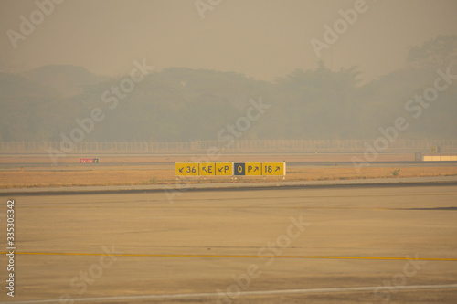 A taxiway sign for guid the aircraft to runway. All covered with air pollution pm 2.5