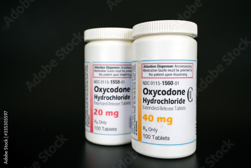 Oxycodone Hydrochloride prescription bottles isolated on black background. Opiod pills, drugs, abuse and narcotics concept. photo