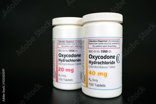 Oxycodone Hydrochloride prescription bottles isolated on black background. Opiod pills, drugs, abuse and narcotics concept.