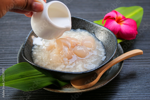 Sticky rice boiled in syrup with longan and coconut milk dressing. Thai dessert
