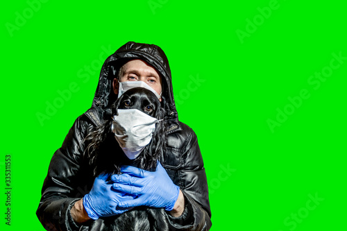 a man in a medical mask and gloves holds his dog in a medical mask