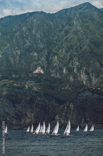 yacht race with white sails on the sea against the background of a huge rock and the city