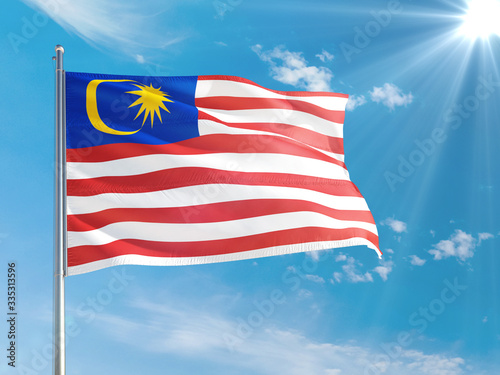 Malaysia national flag waving in the wind against deep blue sky. High quality fabric. International relations concept.