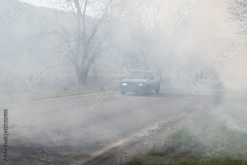 Smoke from fire near the city road © vbaleha