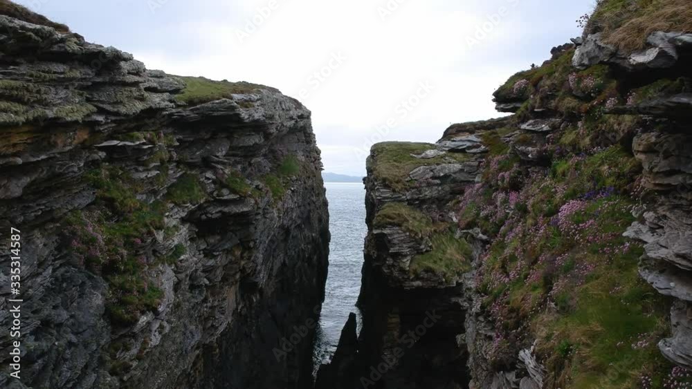 Fly-through push-forward drone shot of ocean cliffs. Aerial video shot in Scotland, highland Fly-through push-forward drone shot of ocean cliffs. Aerial video shot in Scotland, highland