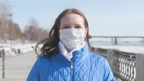 A girl in a protective mask on the street. Prevention and protection of health and safety of life. Coronavirus N1H1, covid-19, pandemic in the world.