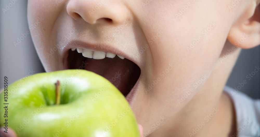 children's teeth bite a green Apple. healthy teeth and care children's teeth bite a green Apple. healthy teeth and care