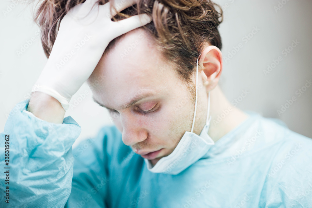 tired and sad doctor surgeon in depression is upset and holds his head. Medical error and professional burnout. tired and sad doctor surgeon in depression is upset and holds his head. Medical error and professional burnout.