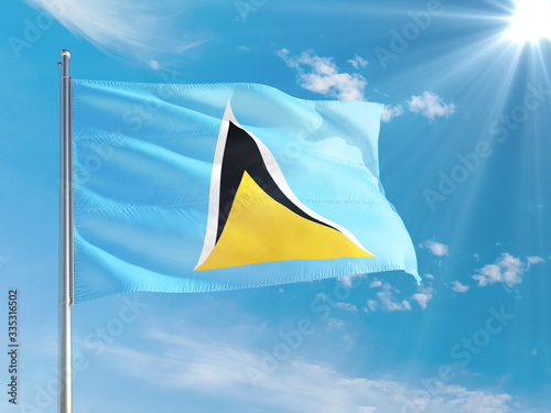 Saint Lucia national flag waving in the wind against deep blue sky. High quality fabric. International relations concept.