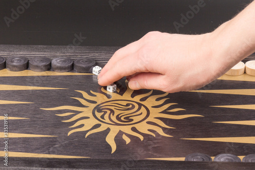 Detail of a backgammon game with two dice close up, on black. Dice on backgammon board game. Selective focus. Playing leisure games photo