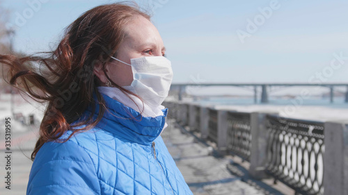 A girl in a protective mask on the street. Prevention and protection of health and safety of life. Coronavirus N1H1, covid-19, pandemic in the world.