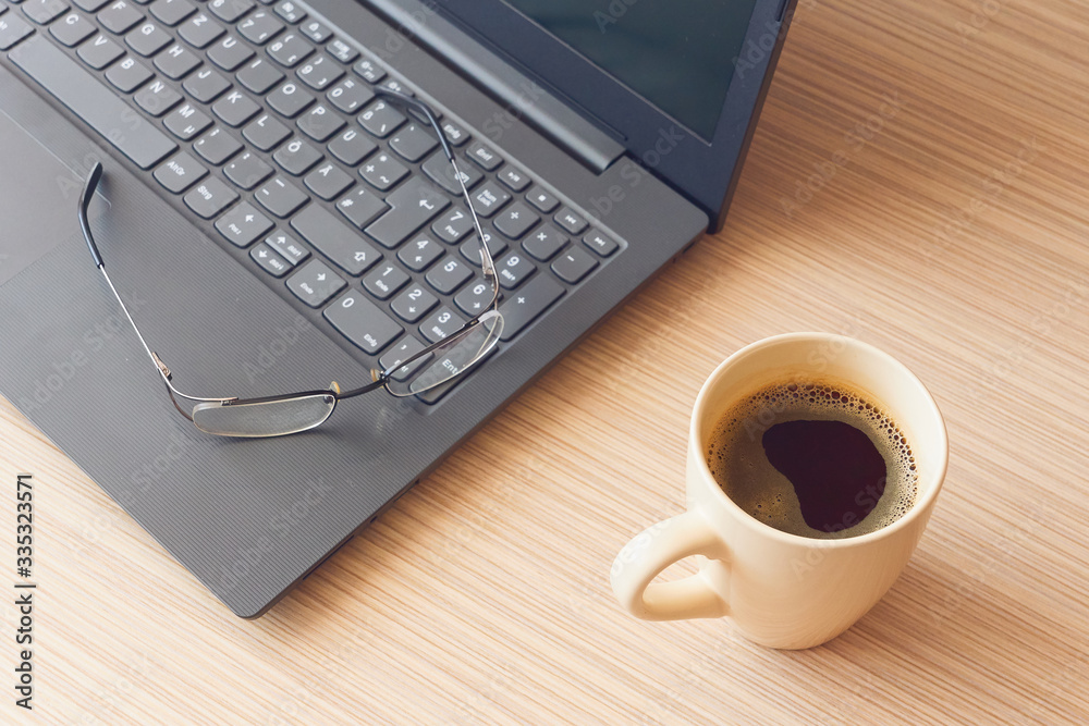 Work from home during coronavirus pandemic , eyeglasses on notebook and coffee mug Work from home during coronavirus pandemic , eyeglasses on notebook and coffee mug