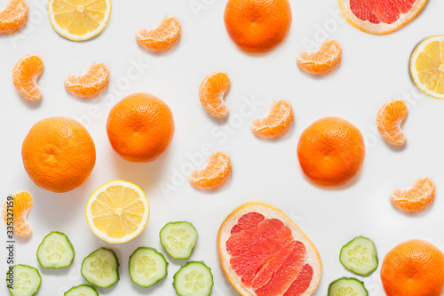 Fruits and vegetables on a white background, including citrus lemon and tangerines, grapefruit and fresh sliced cucumber. concept vitamins, healthy food, backgrounds for grocery stores.
