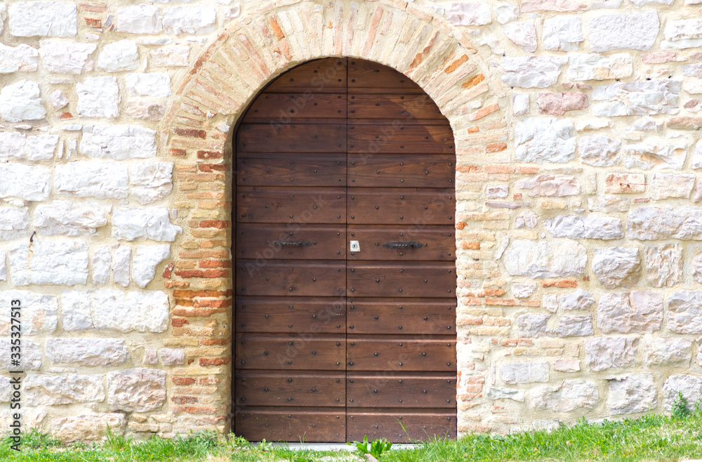 Fototapeta premium Detail of the entrance of the little churc of St. John Baptist in Loreto, Umbria in Italy. It is a good place to stop and rest on the pilgrimage route Saint Francis way