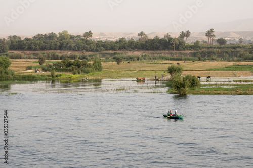 The Nile River in the vicinity of Luxor, Egypt, Africa with its crops, its boats, its towns and its cruise ships. Beautiful view.