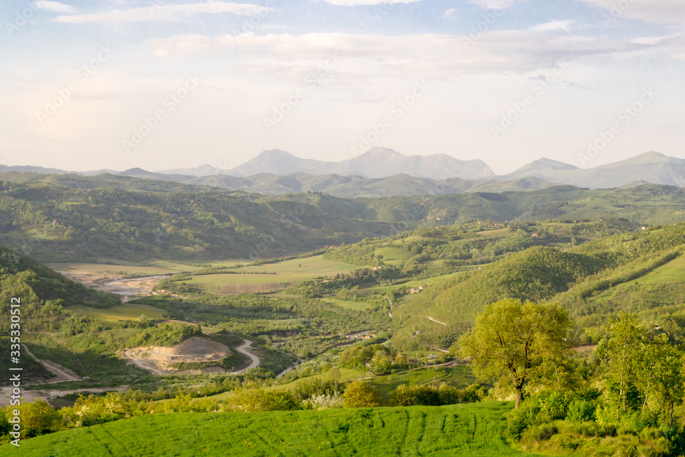 Fototapeta premium Amazing green landscape in central Italy, in Umbria between Gubbio and Assisi. Here the land is highly cultivated and there are a lot of beautiful old trees and many footpaths to walk in the nature
