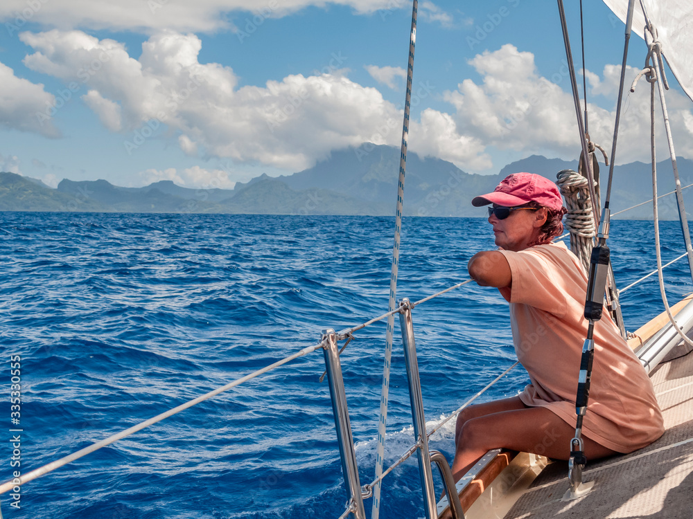 young woman on a sailing yacht,approaching Raiatea Island from sea, French Polynesia, Society Islands, south pacific young woman on a sailing yacht,approaching Raiatea Island from sea, French Polynesia, Society Islands, south pacific