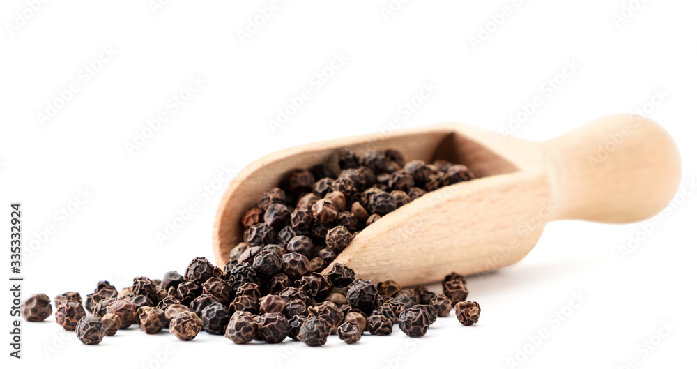 Black pepper seeds in a wooden spoon on a white. Isolated Black pepper seeds in a wooden spoon on a white. Isolated