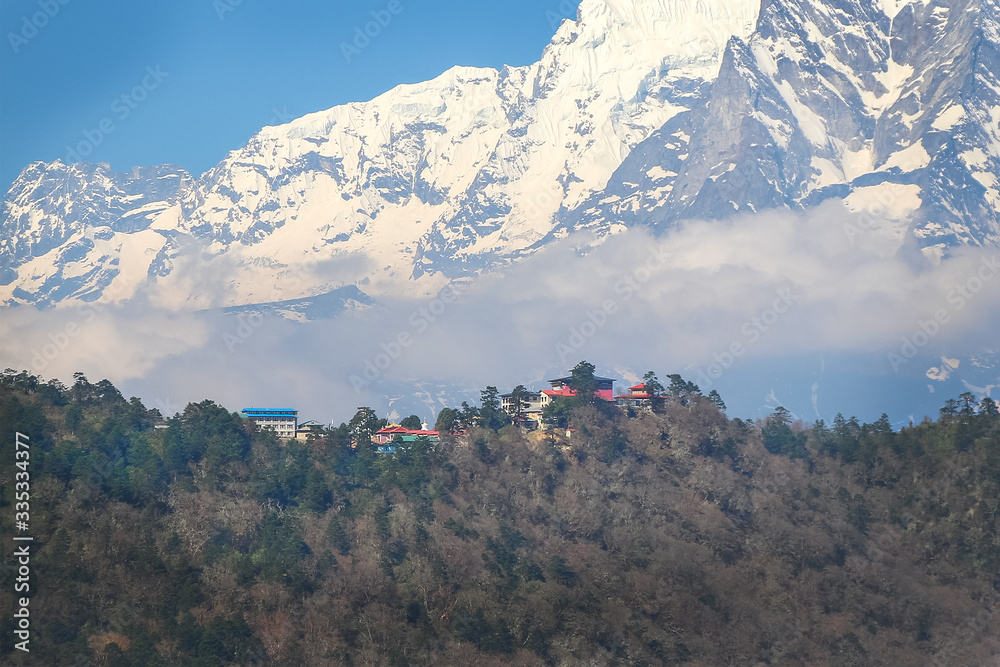 View of Tengboche village with Thyangboche Monastery, also known as Dawa Choling Gompa, from far away. Taboche mountain and clouds in the background. Theme of travel in Nepal. - obrazy, fototapety, plakaty 