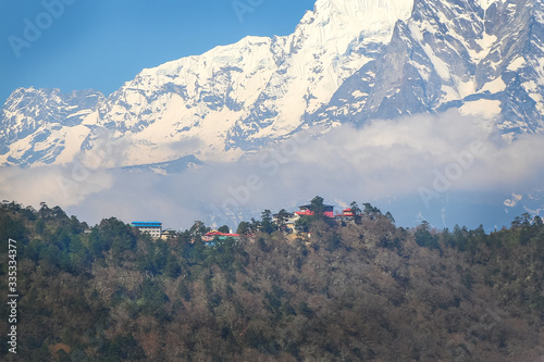 View of Tengboche village with Thyangboche Monastery, also known as Dawa Choling Gompa, from far away. Taboche mountain and clouds in the background. Theme of travel in Nepal. photo