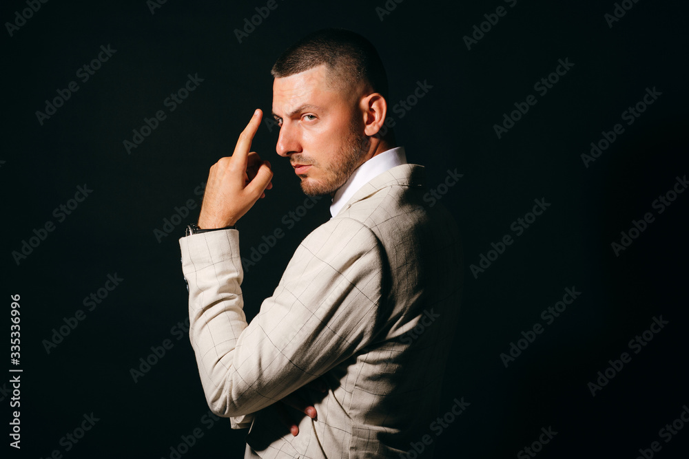 Dramatic portrait of business man in profile with hand near his face on black background. Dramatic portrait of business man in profile with hand near his face on black background.