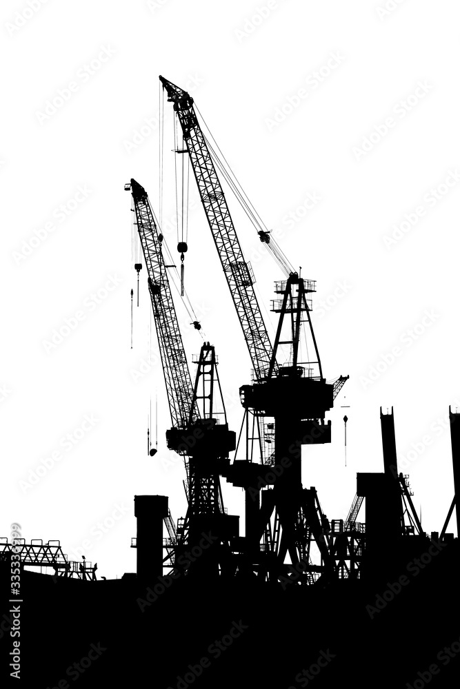 Hamburg, Germany. Cranes silhouetted in the harbor. Black and white.