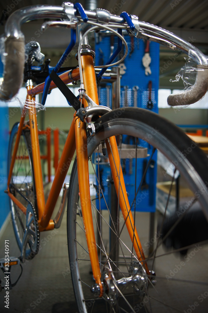 Mechanic or serviceman installing wheel on a bicycle in workshop Mechanic or serviceman installing wheel on a bicycle in workshop