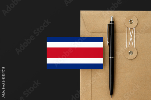 Costa Rica flag on craft envelope letter and black pen background. National invitation concept. Invitation for education theme. photo