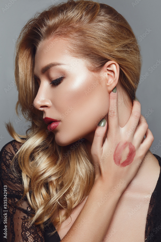 young blonde woman posing with lipstick mark on hand young blonde woman posing with lipstick mark on hand