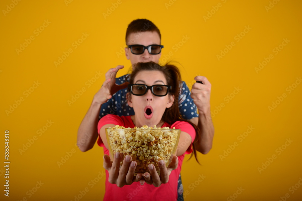 Obraz premium woman and man in 3d glasses with popcorn rest movie advertisement