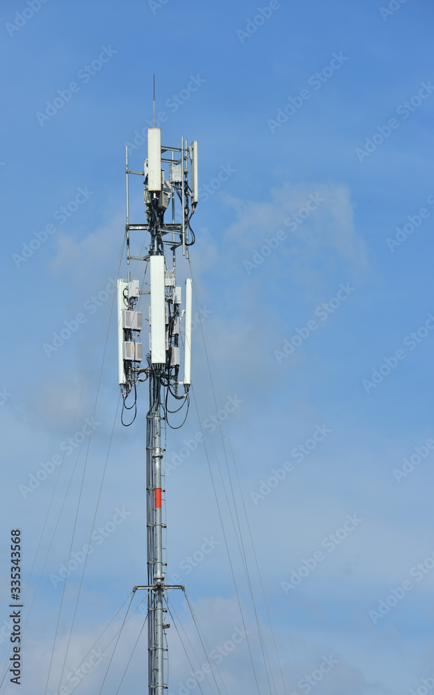 .Wireless Communication Antenna With bright sky.Telecommunication tower with antennas.High pole for signal transmission. There are both wireless phone systems and microwave systems.	